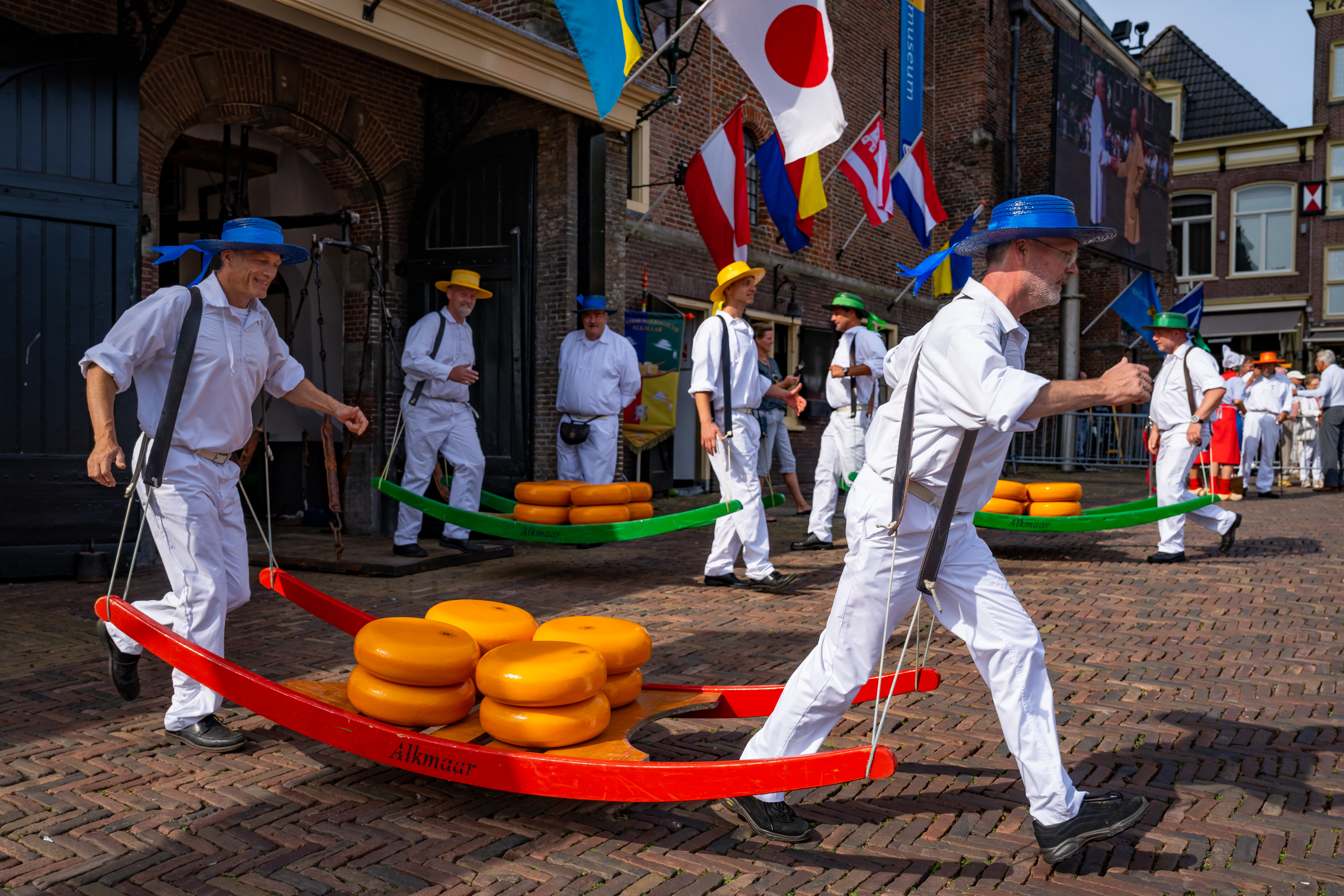 Kaasdragers met blauwe hoeden en een rode kaasberrie